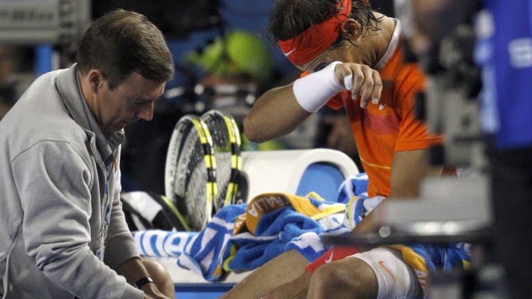 Nadal calls for medical personnel during the second game of the third set.