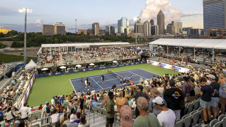 In Atlanta, the bigger Stadium Court sits the coaches at a bit of a distance from the court, with umbrella-covered VIP tables acting as a buffer on one end.