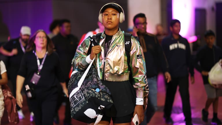 Osaka completes the eye-catching look with a cropped gold warm-up jacket and an on-court bag featuring the same iridescent snake-skin pattern.