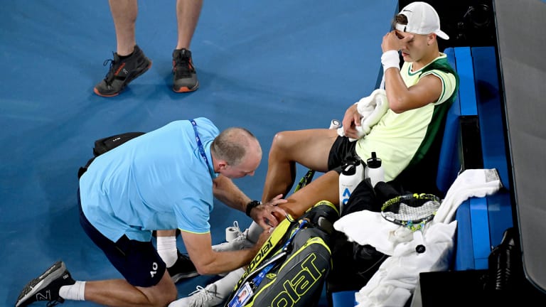 Holger Rune receives treatment on his left knee during his second-round match at the Australian Open.