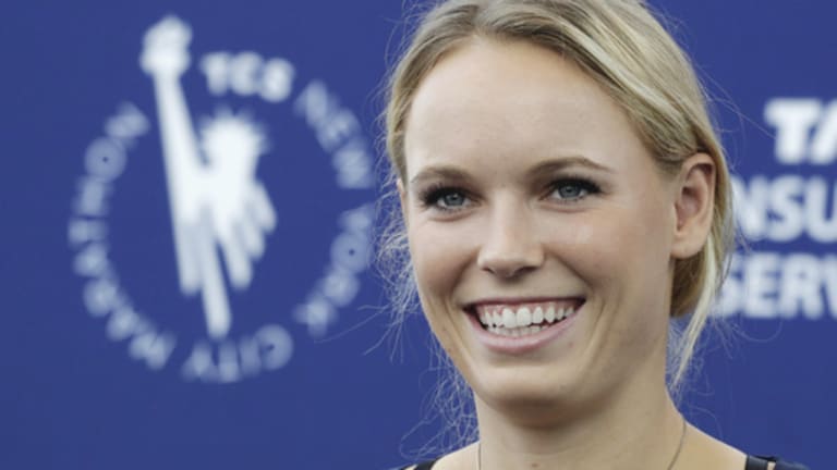 Professional tennis player Caroline Wozniacki talks during a news conference, Wednesday, Oct. 29, 2014, in New York. The Danish tennis star, formerly top-ranked in the world,  will run the New York City Marathon, Sunday, Nov. 2, to raise funds for the New York Road Runners Team for Kids charity, which promotes youth running. (AP Photo/Mark Lennihan)