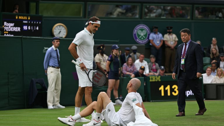 A concerned Federer and court official check on Mannarino.