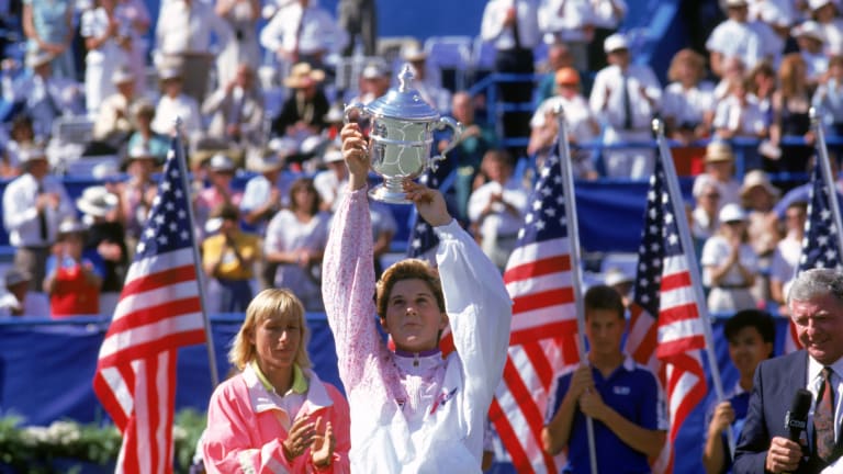 Monica Seles proudly raises her trophy after defeating Martina Navratilova to win the 1991 US Open.