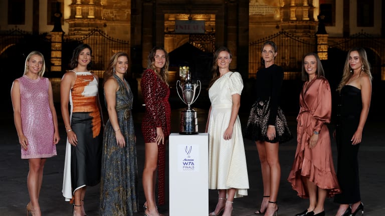 The eight contenders pose with the Billie Jean King trophy during Tuesday evening's draw ceremony.