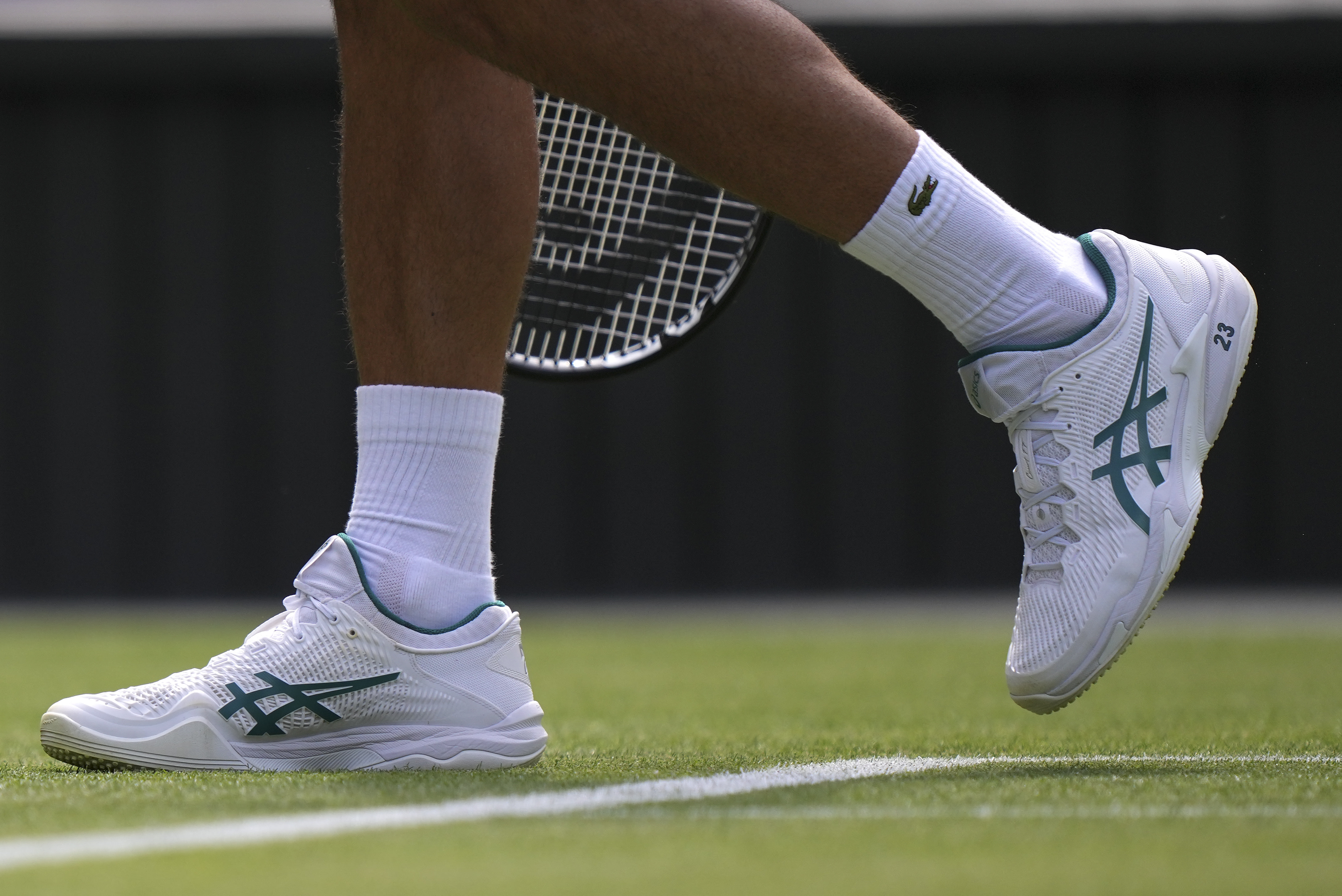 Novak Djokovic plays at Wimbledon with the number 23 printed on his white tennis shoes